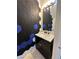Stylish powder room featuring geometric accent wall, decorative lighting, and a black vanity with white sink at 5846 Lee Fairy Ct, Las Vegas, NV 89139