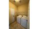 Functional laundry room equipped with a washer, a dryer, shelving, and tiled floors at 5846 Lee Fairy Ct, Las Vegas, NV 89139