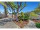Spacious backyard with mature trees, landscaped areas, a brick patio, and an outdoor pergola at 619 D Avenue, Boulder City, NV 89005