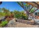 Backyard brick patio featuring lush landscaping, stone retaining walls, and mature trees at 619 D Avenue, Boulder City, NV 89005