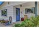 Welcoming front entrance with a blue door, shuttered windows, and a charming porch with lovely potted plants at 619 D Avenue, Boulder City, NV 89005