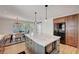 Bright kitchen showcasing a marble island with an undermount microwave, complemented by a dining area and backyard views at 619 D Avenue, Boulder City, NV 89005