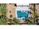 Bird's eye view of a sparkling pool and spa with a nearby covered patio, complemented by lush palm trees at 6489 Crest Estates St, Las Vegas, NV 89131