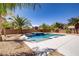 Beautiful backyard oasis featuring a pool, spa, palm trees, gravel landscaping and block wall for privacy at 6489 Crest Estates St, Las Vegas, NV 89131