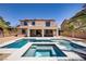 Spacious two-story home with a backyard featuring a pool, spa, covered patio, and mature palm trees at 6489 Crest Estates St, Las Vegas, NV 89131