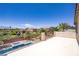 Balcony view showcasing the backyard pool, lush landscaping, neighboring houses, and the clear blue sky above at 6489 Crest Estates St, Las Vegas, NV 89131