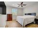 Bedroom with window, dark wood dresser, and queen bed, hardwood flooring, and ceiling fan at 6489 Crest Estates St, Las Vegas, NV 89131