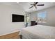 Bedroom boasts wood floors, ceiling fan, access to outdoor patio, large window, and television at 6489 Crest Estates St, Las Vegas, NV 89131
