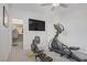 Bright home gym featuring an elliptical machine, rowing machine, and a wall-mounted television and a walk-in closet at 6489 Crest Estates St, Las Vegas, NV 89131