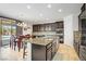 Modern kitchen with a center island, stainless steel appliances, and dark cabinetry at 6489 Crest Estates St, Las Vegas, NV 89131