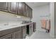 A laundry room with ample cabinet space, sink, modern washer and dryer in a neutral color scheme at 6489 Crest Estates St, Las Vegas, NV 89131