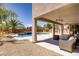 Inviting covered patio with ceiling fans and a view of the refreshing pool and lush landscaping at 6489 Crest Estates St, Las Vegas, NV 89131