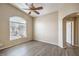 Bright bedroom featuring wood-look floors, a ceiling fan, and a large arched window at 6617 Lavender Lilly Ln # 1, North Las Vegas, NV 89084