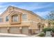 Side view of a townhouse featuring a charming small balcony over a three-car garage at 6617 Lavender Lilly Ln # 1, North Las Vegas, NV 89084