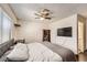 Cozy bedroom featuring a ceiling fan, dark wood floors, and lots of natural light at 7047 Mountain Meadow Ln, Las Vegas, NV 89147