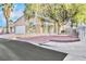 Tan single story home with a white garage door, desert landscaping and a large shade tree in the front yard at 7909 Smokey Ridge Ct, Las Vegas, NV 89131
