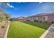 A spacious backyard featuring an artificial lawn and a private pool with a covered pergola at 8445 S Tenaya Way, Las Vegas, NV 89113