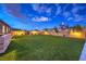 A well-maintained backyard with artificial turf, bordered by a brick wall and manicured landscaping at 8445 S Tenaya Way, Las Vegas, NV 89113
