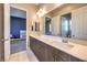 Bathroom with double vanity sinks, quartz countertops, wood cabinets, and modern lighting fixtures at 8445 S Tenaya Way, Las Vegas, NV 89113