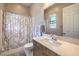 Bright bathroom featuring a shower with decorative curtain and a vanity with a white countertop and modern faucet at 8445 S Tenaya Way, Las Vegas, NV 89113