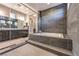 The bathroom has a soaking tub set behind a frameless glass enclosure with gray tile at 8445 S Tenaya Way, Las Vegas, NV 89113