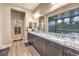The spacious bathroom boasts granite countertops, wood cabinets, and a large mirror over the sinks at 8445 S Tenaya Way, Las Vegas, NV 89113
