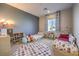 A bedroom with two beds, colorful decor, a round rug, and a large window at 8445 S Tenaya Way, Las Vegas, NV 89113