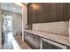 Custom butler's pantry with dark wood cabinetry, granite counters, wine fridge, tile backsplash, and wood-look flooring at 8445 S Tenaya Way, Las Vegas, NV 89113