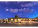 Charming single-story home featuring a three-car garage, desert landscaping, and inviting curb appeal at dusk at 8445 S Tenaya Way, Las Vegas, NV 89113