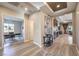 Open-concept home foyer featuring stylish wood-look flooring, designer lighting, and views into office and living areas at 8445 S Tenaya Way, Las Vegas, NV 89113