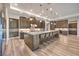 Well-equipped kitchen with dark wood cabinets, an oversized island, pendant lights, and stainless steel appliances at 8445 S Tenaya Way, Las Vegas, NV 89113