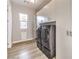 Well-equipped laundry room with modern washer/dryer, storage cabinets, wood-look floors, and plenty of natural light at 8445 S Tenaya Way, Las Vegas, NV 89113