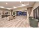 Inviting living room with an open floor plan, wood-look floors, and seamless indoor-outdoor living with sliding glass doors at 8445 S Tenaya Way, Las Vegas, NV 89113