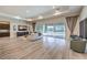 Bright living room featuring wood-look floors, neutral tones, recessed lighting, and large sliding doors to the backyard at 8445 S Tenaya Way, Las Vegas, NV 89113