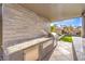 Covered outdoor kitchen offers granite countertops, a built-in grill, and ample storage at 8445 S Tenaya Way, Las Vegas, NV 89113