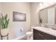 Stylish powder room features a floating vanity, elegant mirror, and decorative plant at 8445 S Tenaya Way, Las Vegas, NV 89113