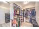 A spacious walk-in closet featuring custom built-in shelves, laundry appliances, and ample clothing storage at 8445 S Tenaya Way, Las Vegas, NV 89113