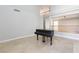 Neutral living room boasts an open floor plan, tile flooring, neutral paint and a grand piano at 8617 Copper Ridge Ave, Las Vegas, NV 89129