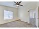 Bright bedroom featuring neutral carpet, ceiling fan, and a large window at 8787 Tom Noon Ave # 101, Las Vegas, NV 89178