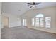 Bright living room with fan, vaulted ceiling, arched entry and views of neighborhood outside at 8787 Tom Noon Ave # 101, Las Vegas, NV 89178