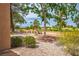 Lush backyard with mature trees, gravel landscaping, and views of the surrounding golf course at 9000 Sundial Dr, Las Vegas, NV 89134