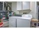 Laundry room with modern washer, dryer, and overhead cabinets for storage at 9000 Sundial Dr, Las Vegas, NV 89134