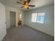 Bedroom featuring neutral carpeting, ceiling fan and entrances to a bathroom and closet at 9267 Lapeer St, Las Vegas, NV 89178