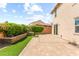 Backyard features paver patio, lush landscaping, and exterior building features at 9277 Ardoa Ave, Las Vegas, NV 89148