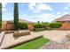 Wide backyard shot featuring artificial turf, paver patio and beautiful landscaping at 9277 Ardoa Ave, Las Vegas, NV 89148