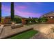 Inviting backyard with a custom fire pit, lush landscaping, and ample space for entertaining at 9277 Ardoa Ave, Las Vegas, NV 89148