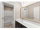Elegant bathroom featuring a marble countertop, gold fixtures, and a large mirror reflecting the shower and door at 9277 Ardoa Ave, Las Vegas, NV 89148