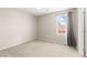 Neutral bedroom with carpet, window with outside view, and a closed door leading to closet space at 9277 Ardoa Ave, Las Vegas, NV 89148