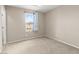 Neutral carpeted bedroom with natural light and neighborhood view streaming through an open window at 9277 Ardoa Ave, Las Vegas, NV 89148