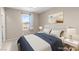 Virtually staged bedroom with a window view, featuring comfortable bed, side tables and lighting at 9277 Ardoa Ave, Las Vegas, NV 89148